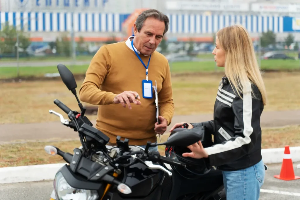 Instrutor conversando com motociclista durante aula de pilotagem