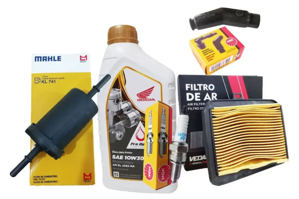 Kit de peças originais para revisão de moto Honda, incluindo óleo de motor Honda SAE 10W30, filtro de combustível Mahle KL 741, filtro de ar, duas velas de ignição NGK e um cachimbo de vela, dispostos sobre fundo branco.