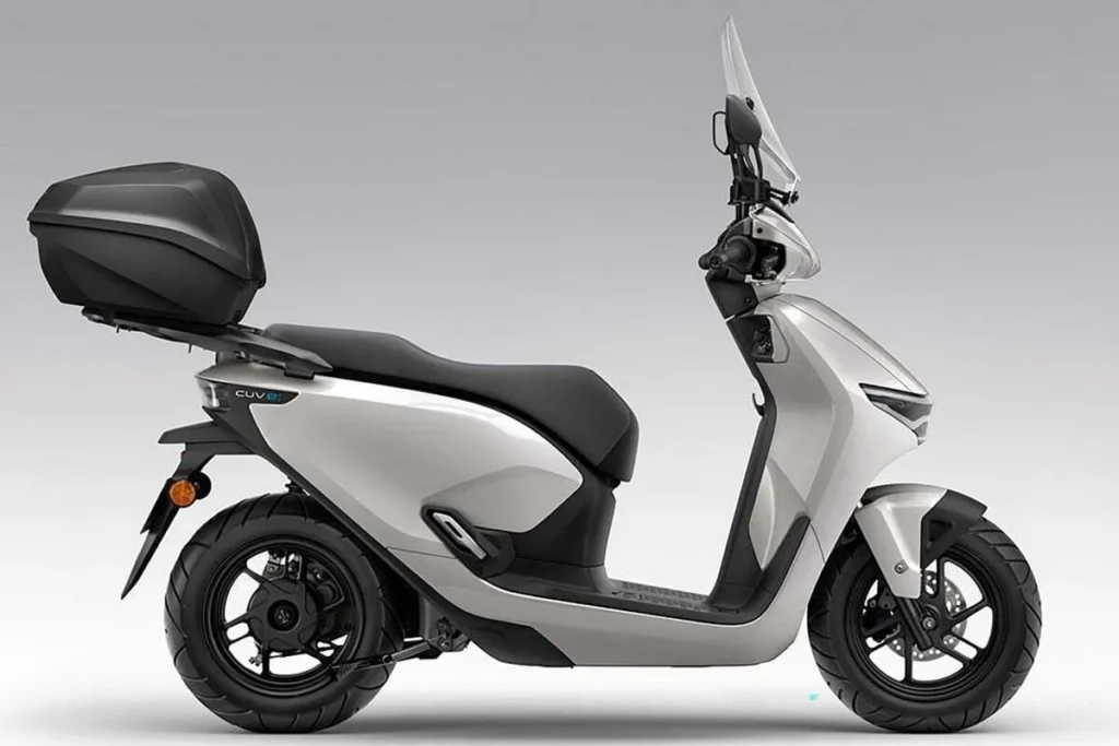 Scooter elétrica moderna na cor prata, com design aerodinâmico, para-brisa e bagageiro traseiro. Veículo de mobilidade urbana e ecológica.